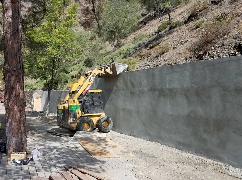 concrete retaining wall holding back hillside soil and stabilizing slope in Cincinnati Ohio