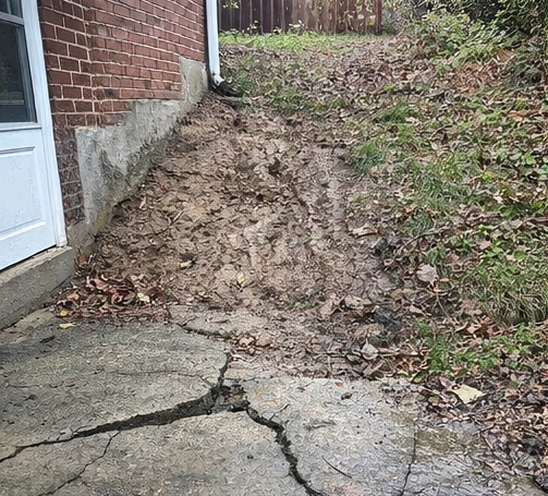 cracks in soil and concrete near home foundation caused by hillside movement in Cincinnati Ohio