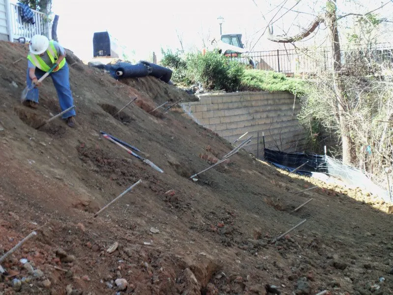 steep unstable hillside with loose soil and reinforcement rods showing early slope failure in Cincinnati Ohio