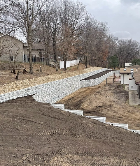 Retaining wall replacement project in Cincinnati showing excavation and new block wall installation