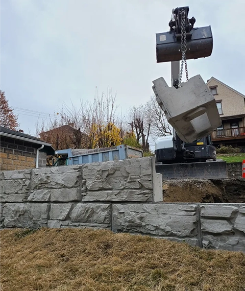 New retaining wall construction in Cincinnati showing base preparation and block installation