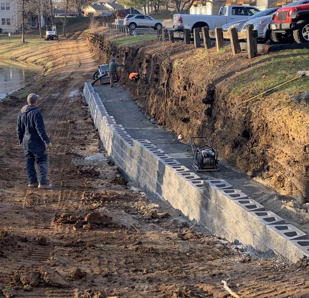 retaining wall base preparation with gravel compaction and leveling for structural stability