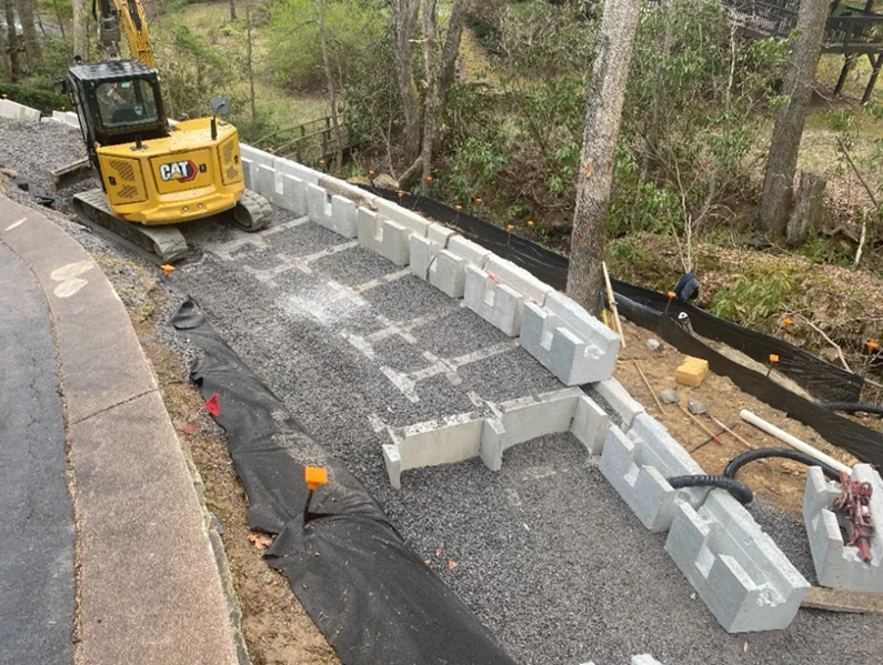 Retaining wall construction job site in Cincinnati with excavation equipment and installation in progress