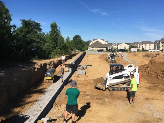 retaining wall construction crew in Cincinnati installing structural block wall and excavation
